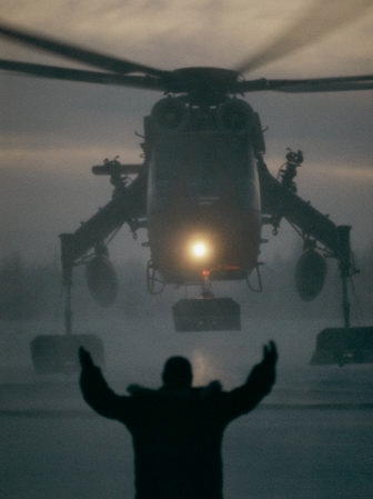 A Man Guides a Landing Helicopter - Art Print