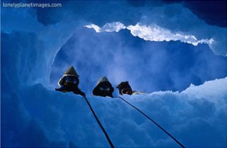 Three Explorers Looking Through Hole in Ice, Antarctica, art print